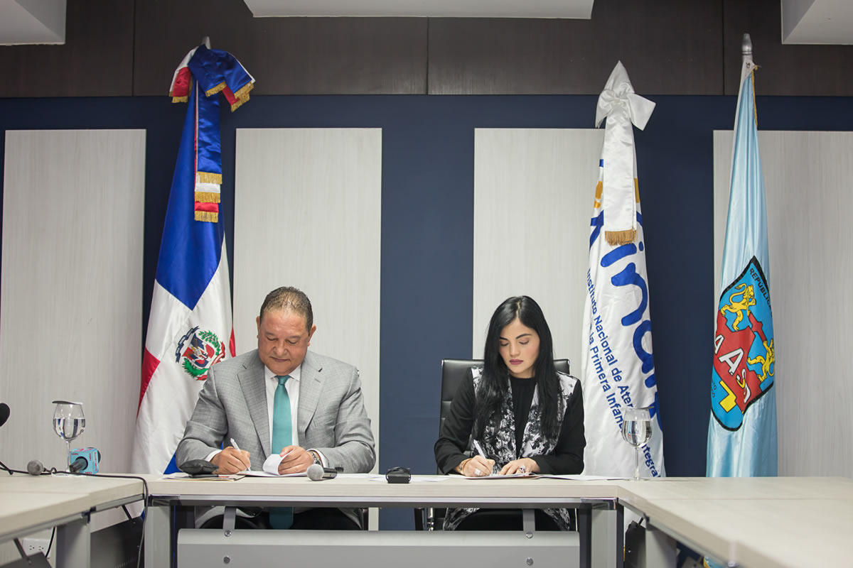 El director de la CAASD, Alejandro Montás, y la Directora Ejecutiva del INAIPI, Berlinesa Franco, mientras rubrican el convenio entre las dos instituciones