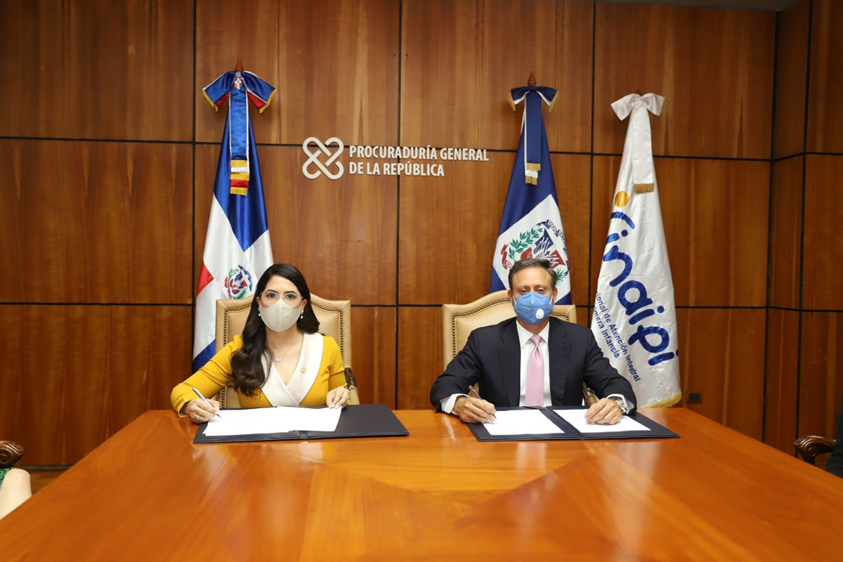 El procurador general, Jean Rodríguez, y la directora del INAIPI, Kenia Ivet Lora Abreu, durante la firma del acuerdo