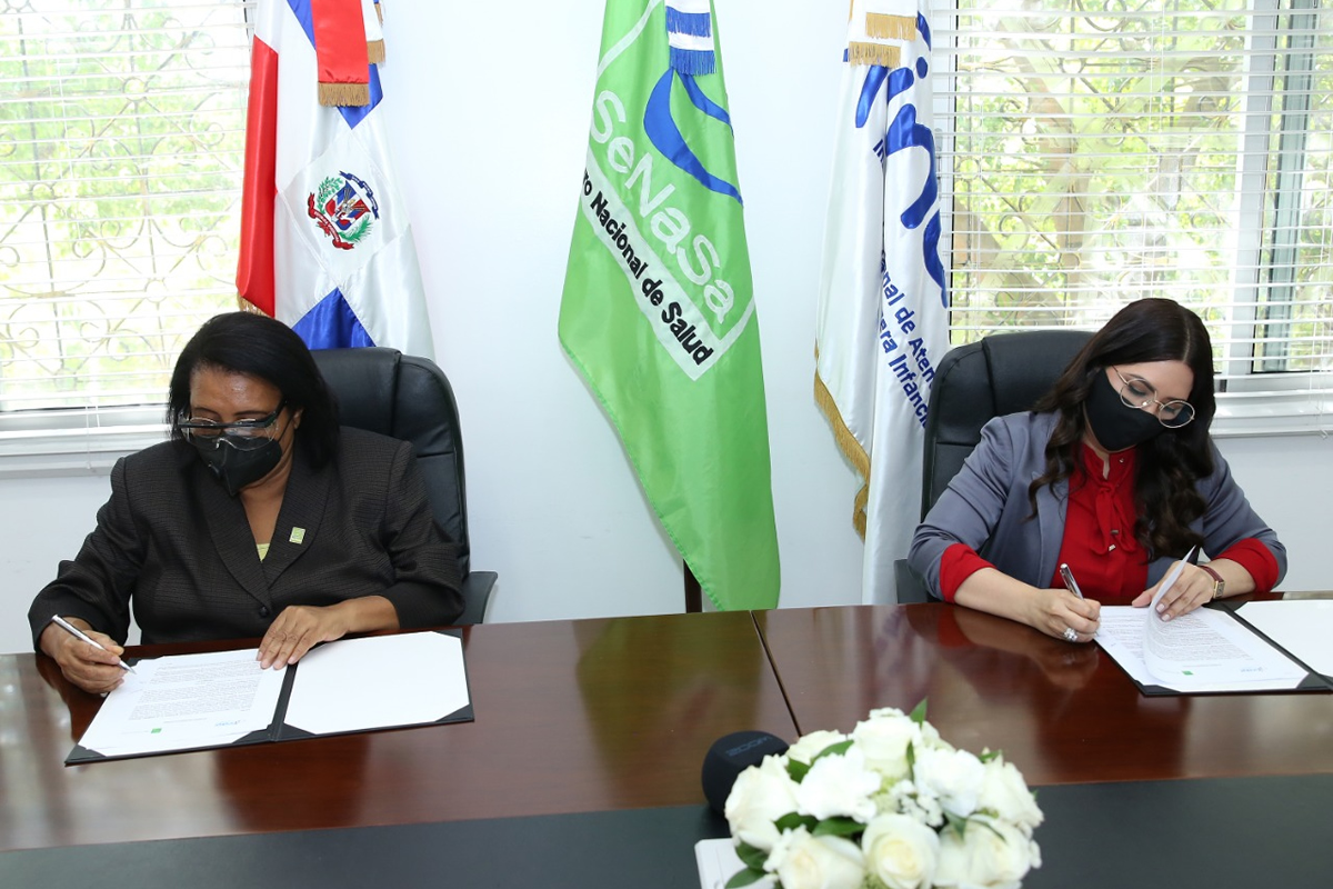 Mercedes Rodríguez Silver, directora ejecutiva de SeNaSa, y Kenia Lora, directora del INAIPI, durante la firma del acuerdo