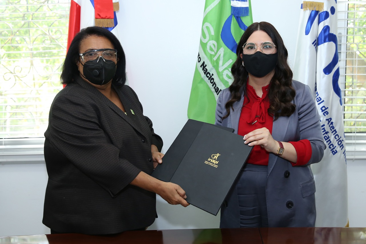 Mercedes Rodríguez Silver, directora ejecutiva de SeNaSa, y Kenia Lora, directora del INAIPI, durante la firma del acuerdo