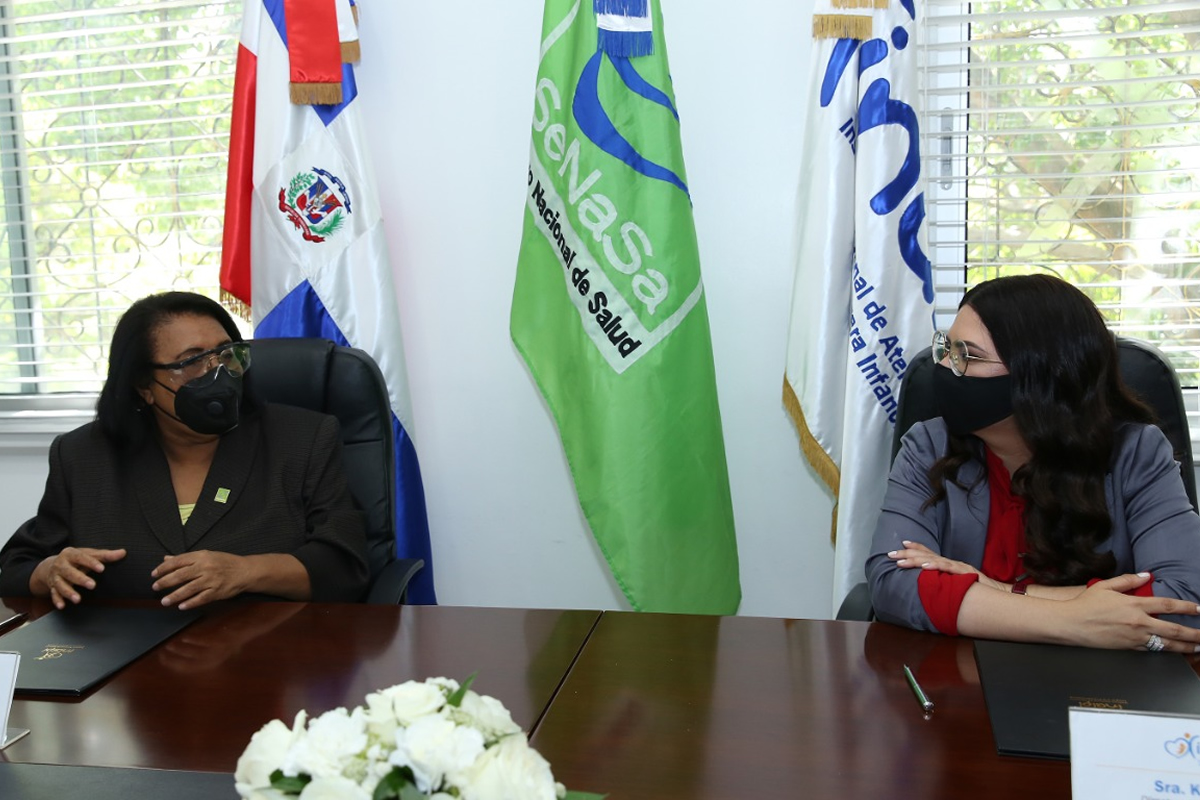 Mercedes Rodríguez Silver, directora ejecutiva de SeNaSa, y Kenia Lora, directora del INAIPI, durante la firma del acuerdo