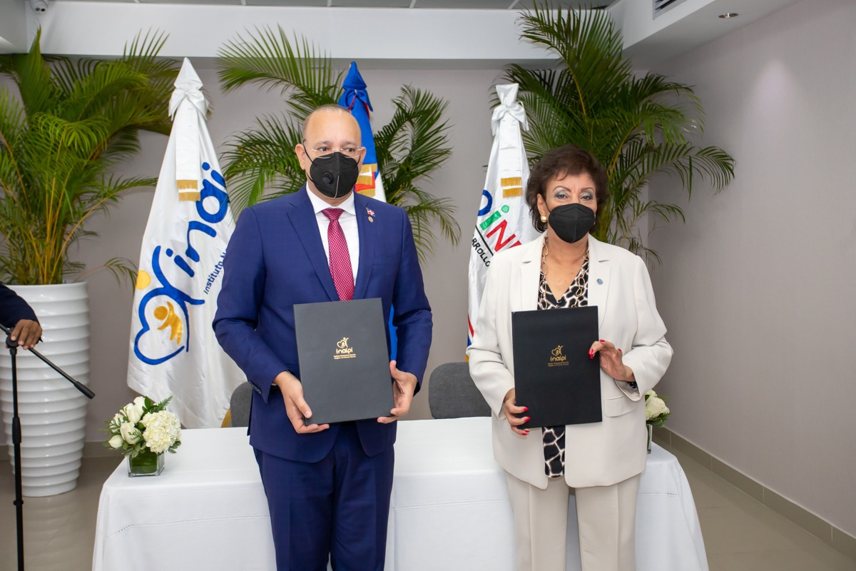  Manola Santana de Báez y Ulises Rodríguez, muestran las carpetas que contienen el acuerdo interinstitucional.