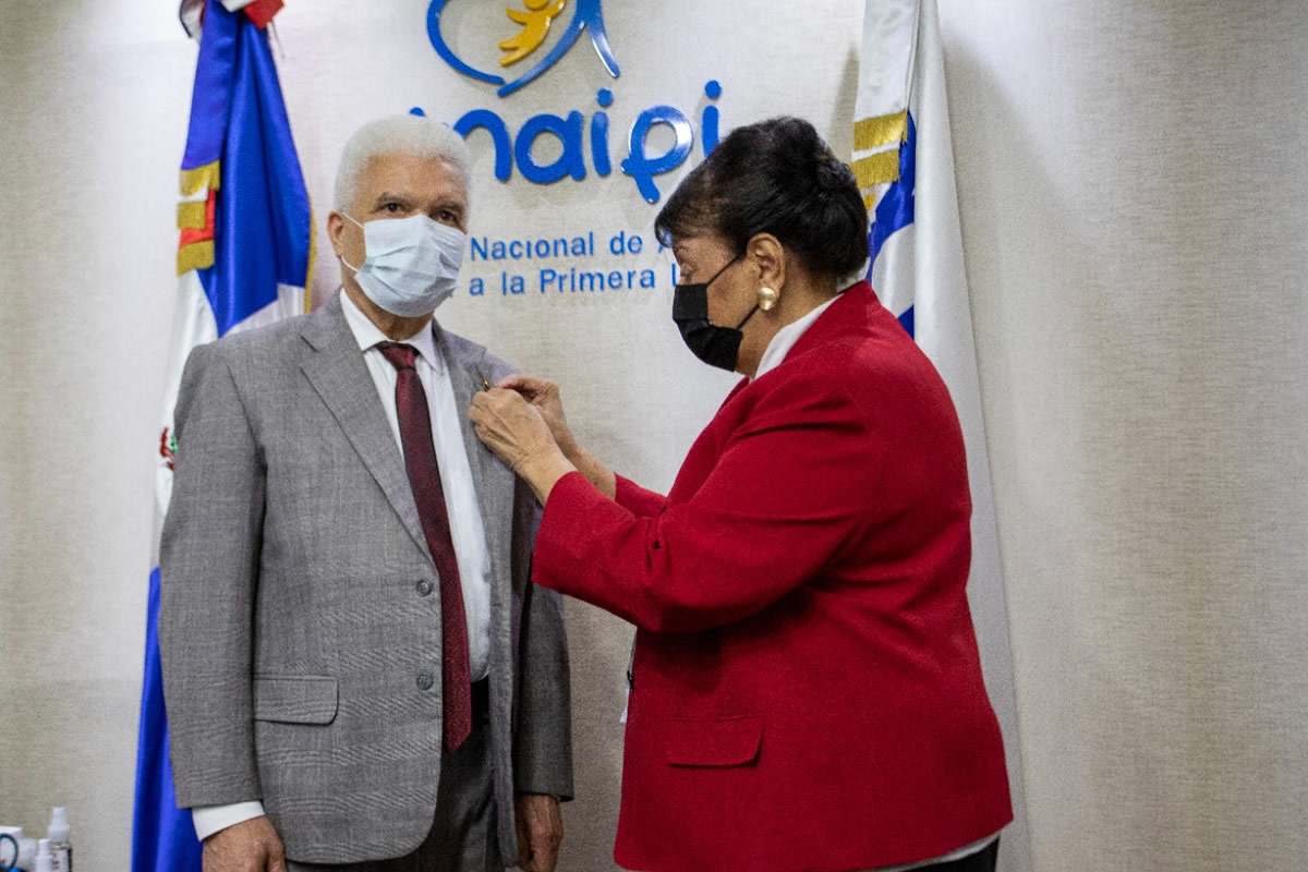 Durante el encuentro, Besaida Manola Santana de Báez colocó el pin institucional al viceministro Administrativo y Financiero de la MESCYT, José Antonio Cancel