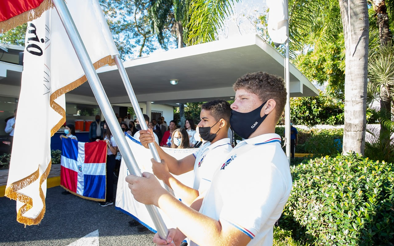 epresentación de estudiantes del Colegio Santo Domingo portando banderas dominicanas