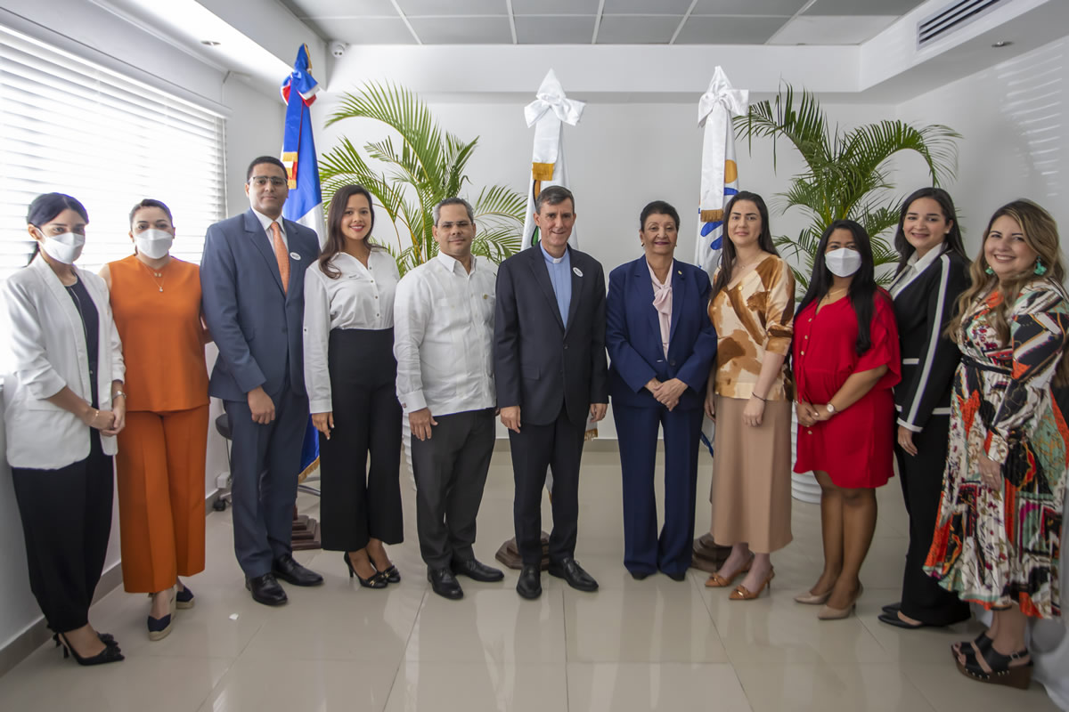 Al centro Henry Rosa, el Padre Jorge William Hernández y Besaida Santana, acompañada de personalidades de ambas instituciones