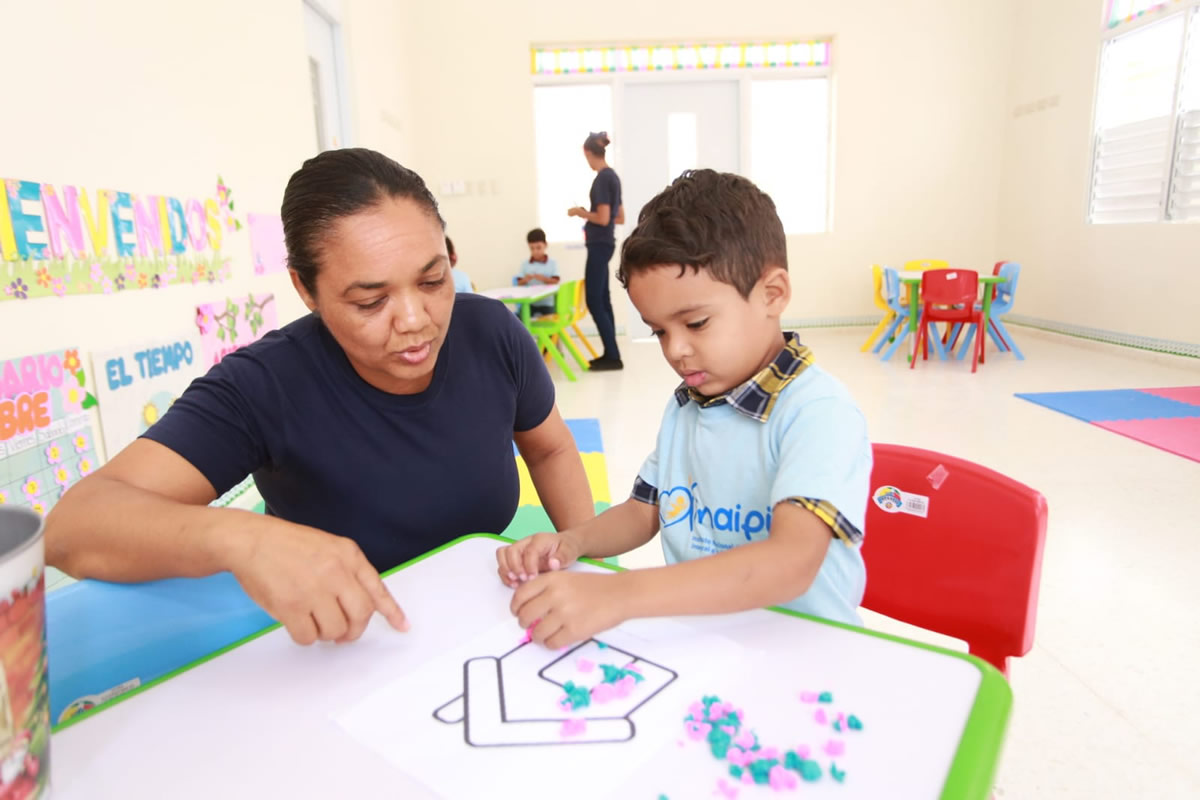 Colaboradora junto a niño en el aula del Nuevo Centro San Victor