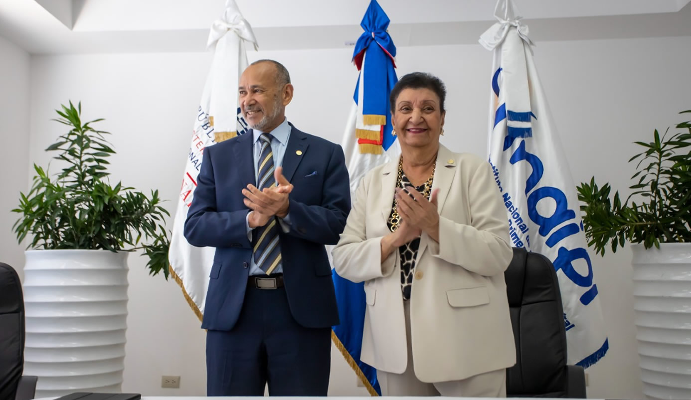 Víctor Castro, director ejecutivo del INABIE y Besaida Manola Santana de Báez, directora ejecutiva del Inaipi , aplauden tras firmar el acuerdo