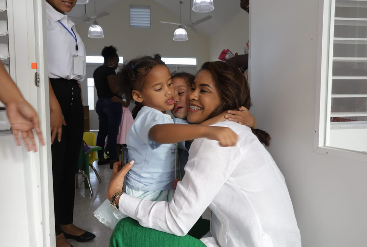 Yanina Torres, subdirectora de Gestión Operativa y Territorial del INAIPI, abraza a dos niños en la inauguración