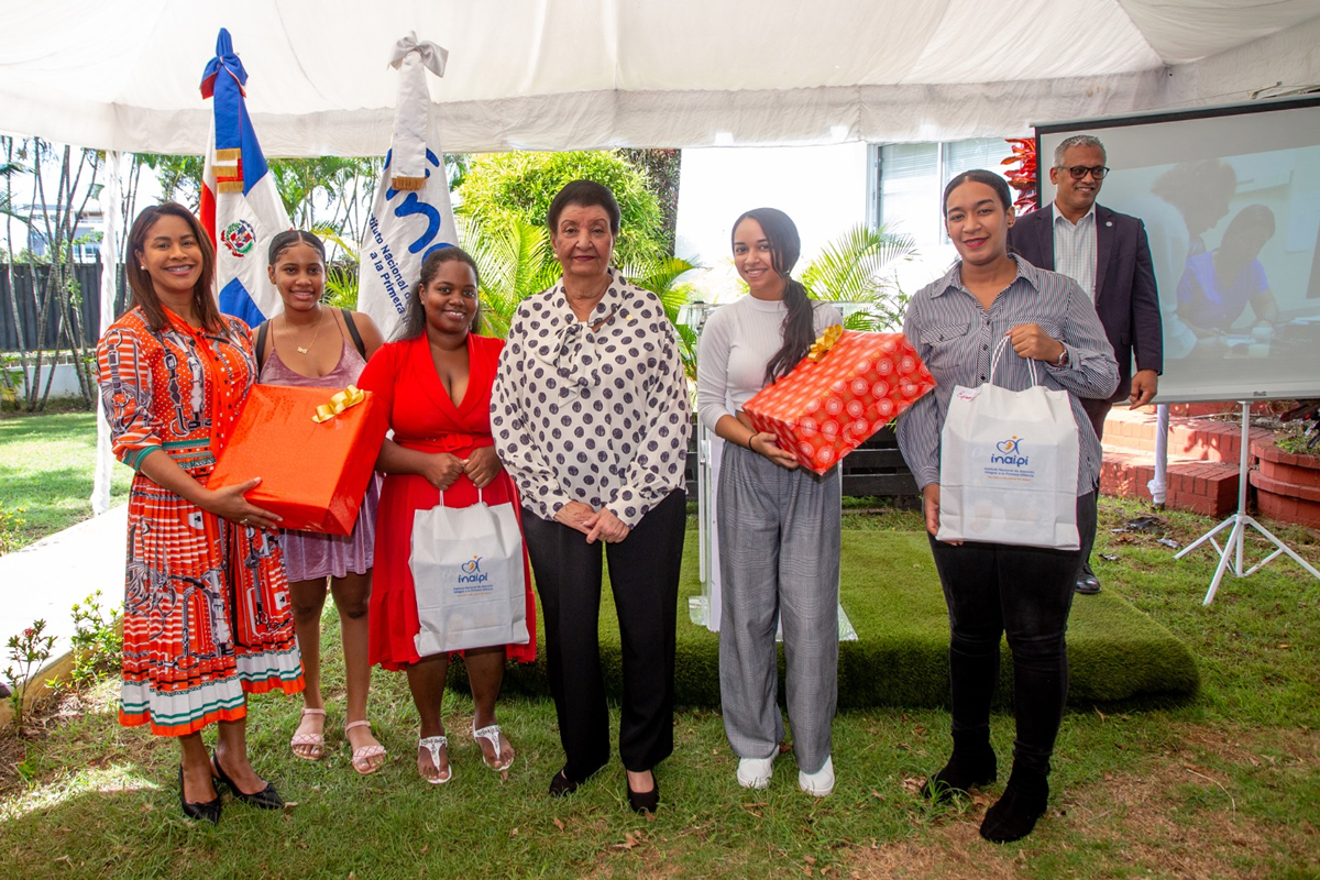 Besaida Manola Santana de Báez, directora ejecutiva del Inaipi, junto a madres que asistieron a acto