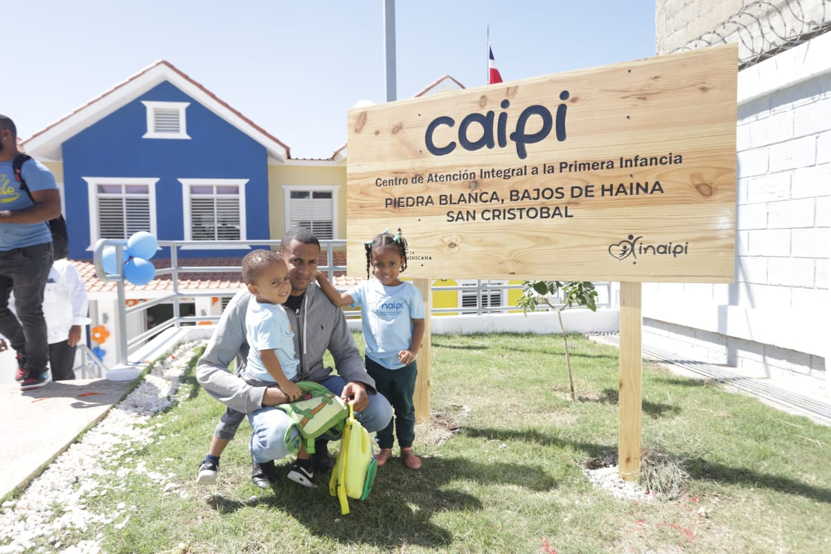 Padre junto a hijos posan en la entrada del nuevo Centro