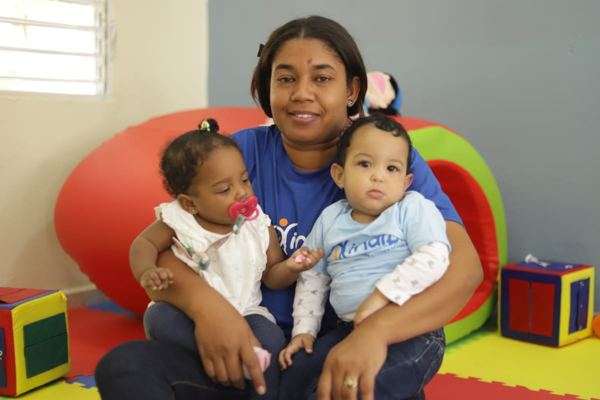 Colaboradora del INAIPI carga niños en el nuevo Centro