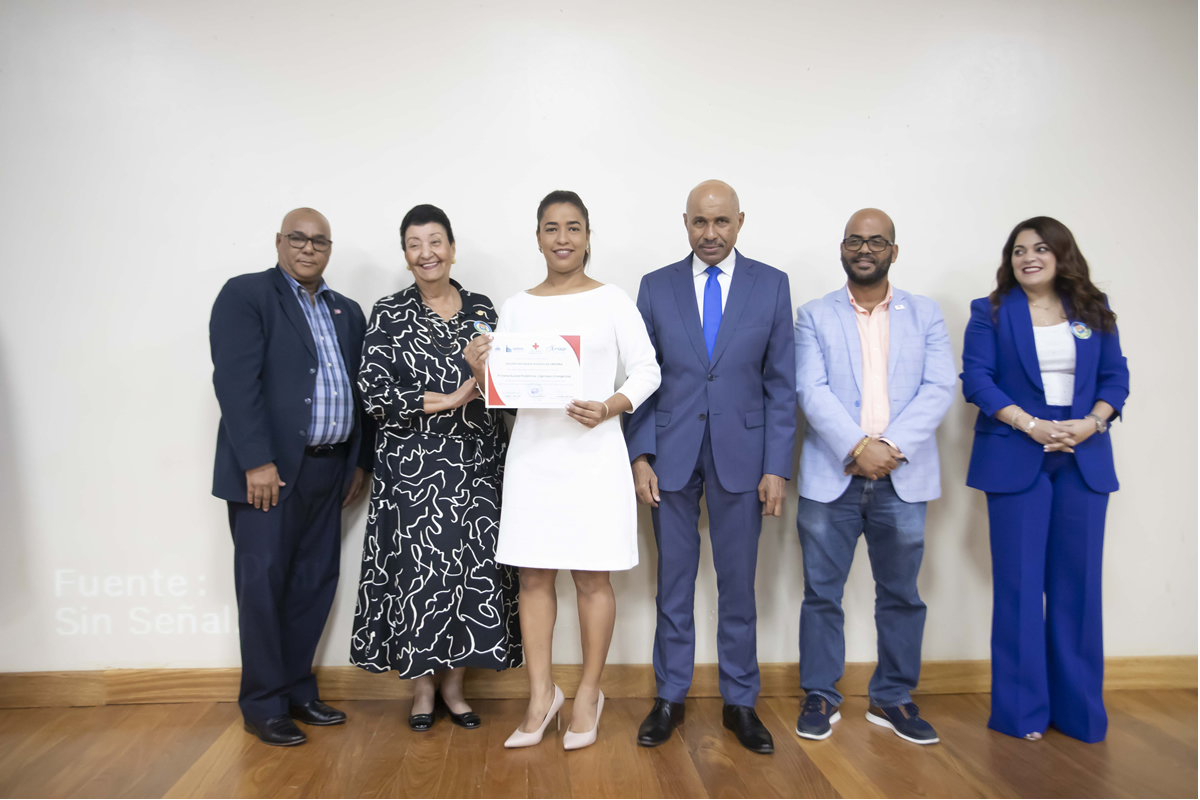 Besaida Manola Santana, directora ejecutiva del INAIPI, junto a invitados entrega reconocimiento  
