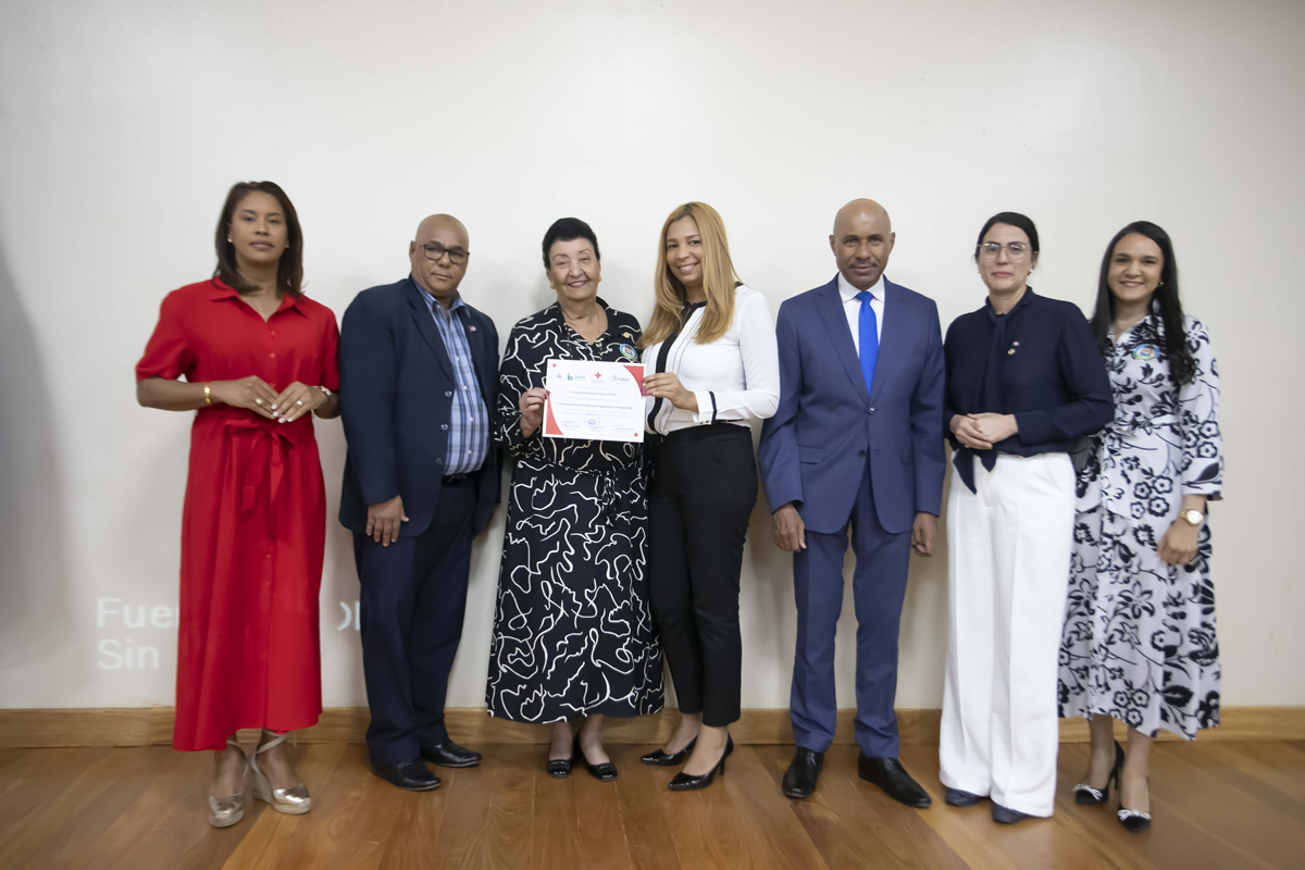 Besaida Manola Santana, directora ejecutiva del INAIPI, junto a invitados entrega reconocimiento  