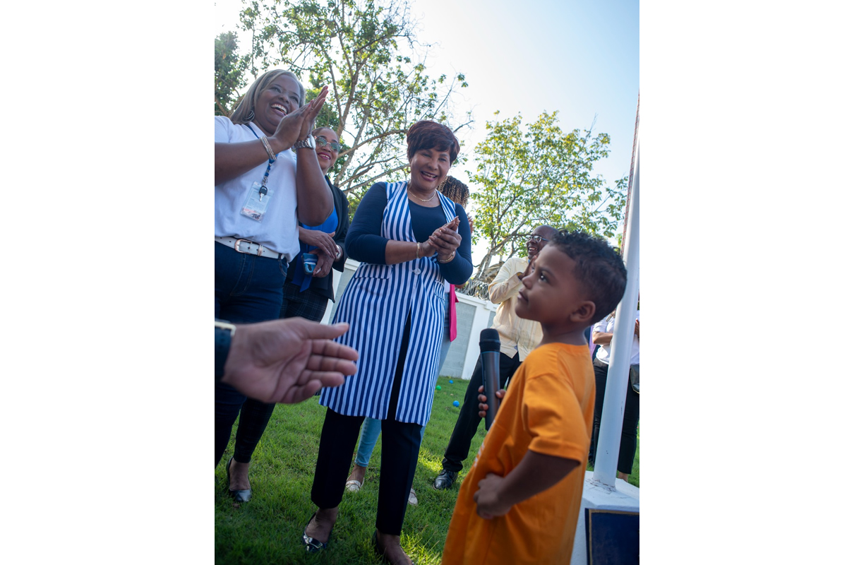 Josefa Castillo Rodríguez, directora del INAIPI, comparte con los niños durante el izamiento de la bandera en la apertura de los servicios.