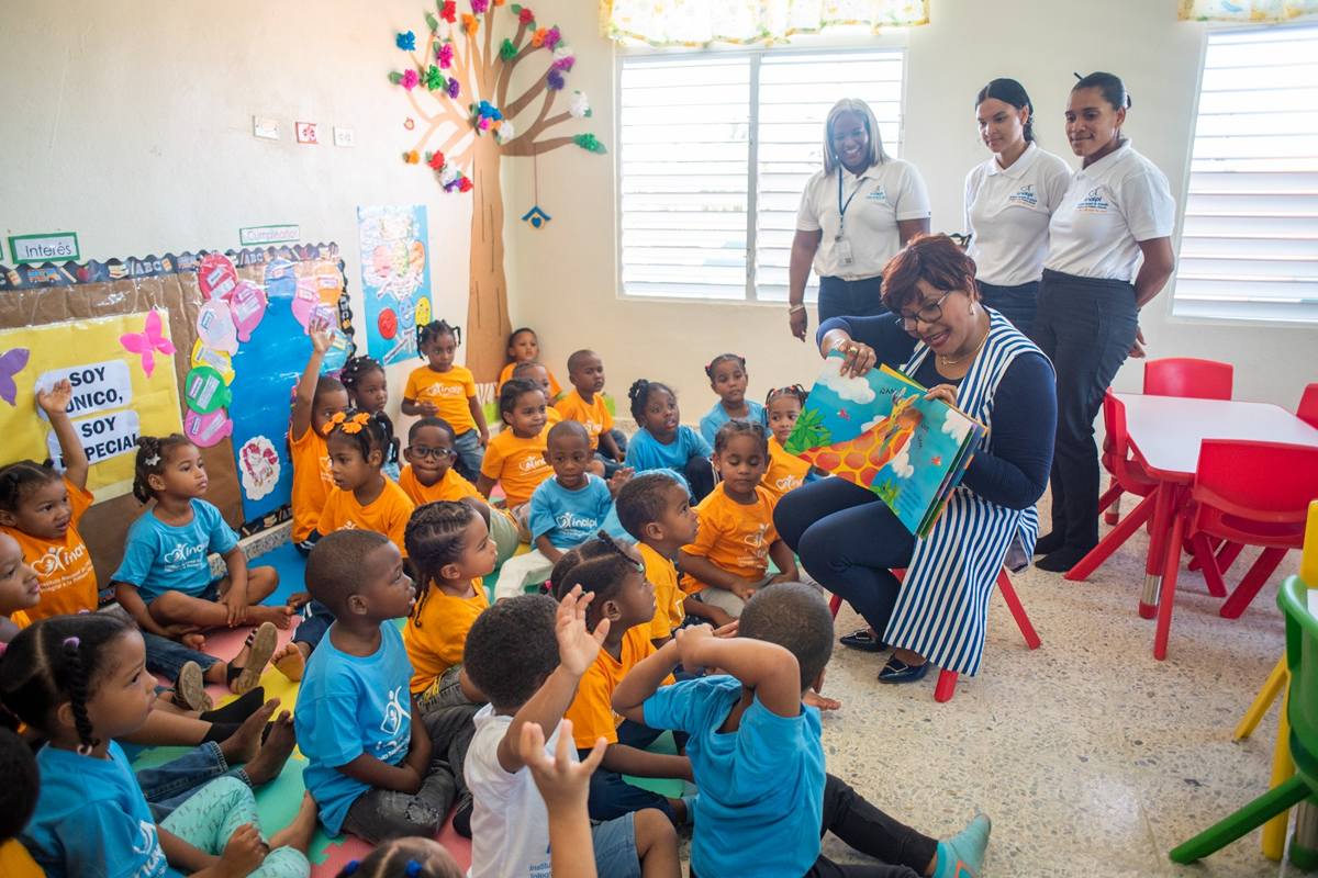 Josefa Castillo Rodríguez, directora del INAIPI, comparte con los niños en el aula mientras les lee un cuento durante el inicio de los servicios.
