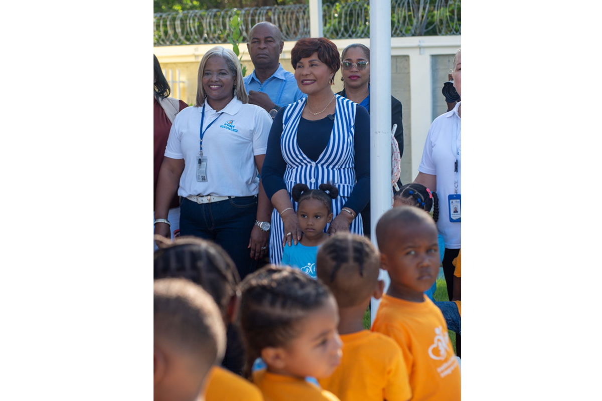 Josefa Castillo Rodríguez, directora del INAIPI, comparte con los niños durante el izamiento de la bandera en la apertura de los servicios.