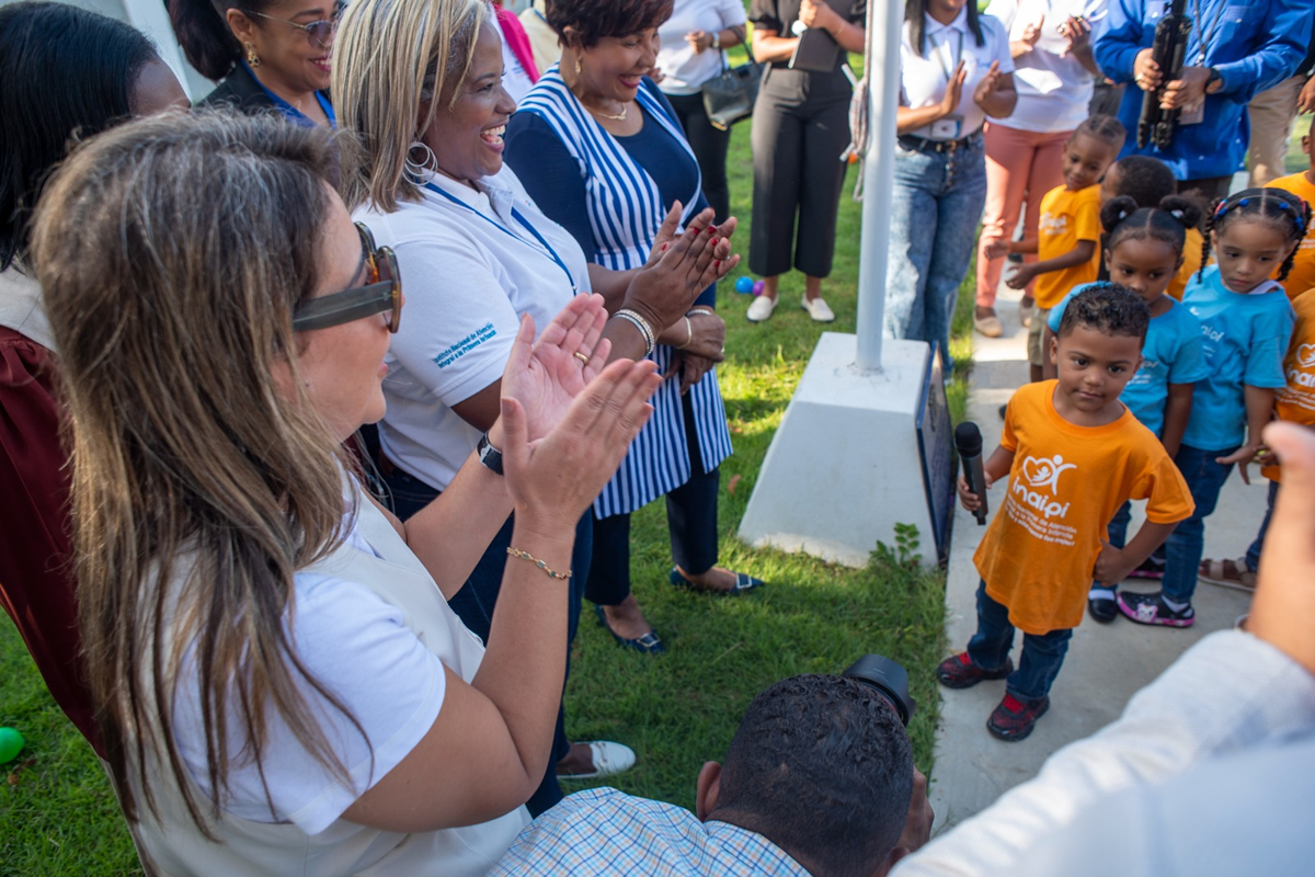Josefa Castillo Rodríguez, directora del INAIPI, comparte con los niños durante el izamiento de la bandera en la apertura de los servicios.