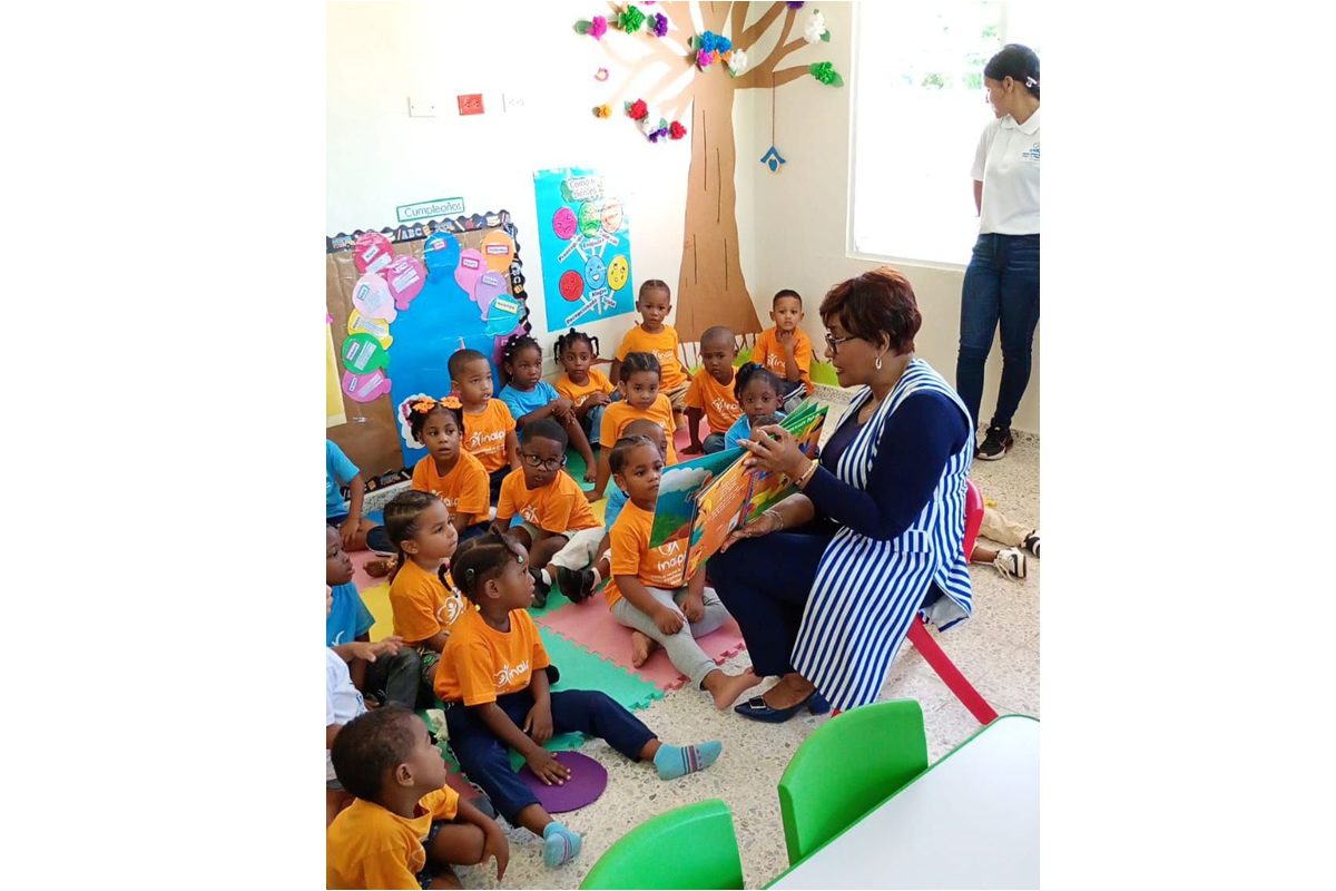 Josefa Castillo Rodríguez, directora del INAIPI, comparte con los niños en el aula mientras les lee un cuento durante el inicio de los servicios