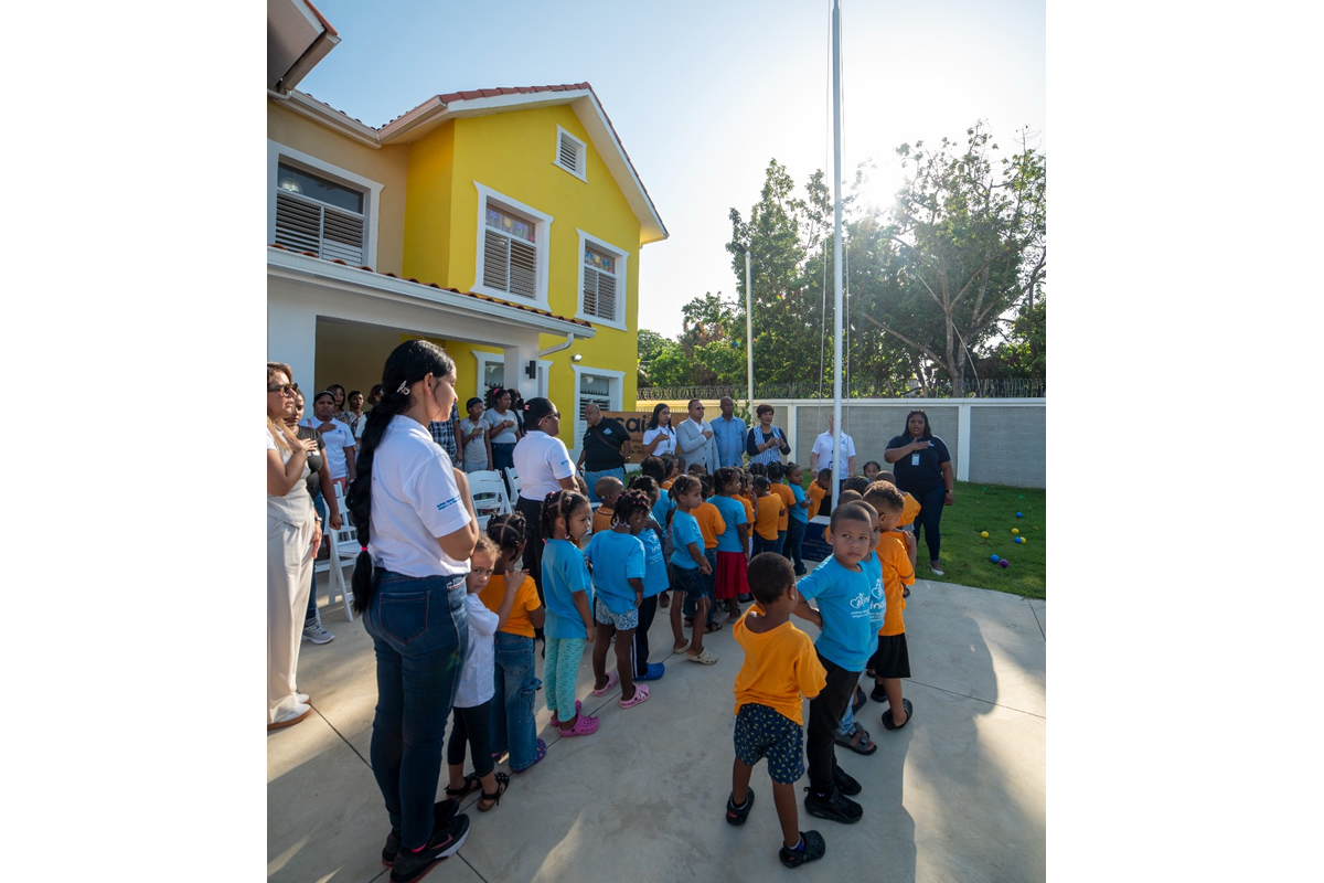 Josefa Castillo Rodríguez, directora del INAIPI, en el izamiento de la bandera junto a niños y colaboradores de la institución